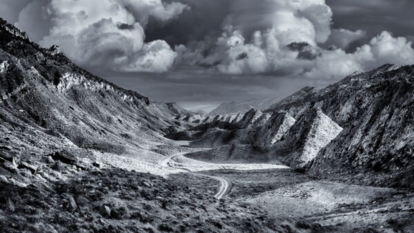By Michael Piraino Black and white of dirt road winding through remote canyon in Southern Utah
