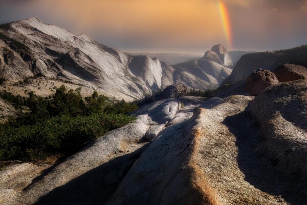 By Michael Piraino rainbow over mountains and Half Dome in Yosemite National Park