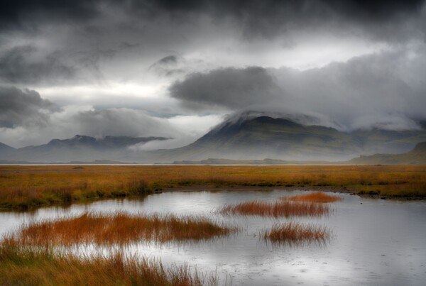 By Michael Piraino Lake, mountains, fog and storm clouds in the Eastern fjords of Iceland in autumn