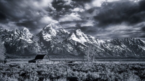 By Michael Piraino Mormon barns in Grand Teton National Park mountain range in black and white