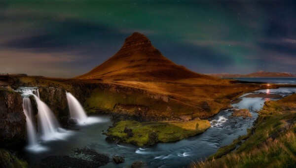 By Michael Piraino Mountain with waterfalls and aurora borealis in Iceland