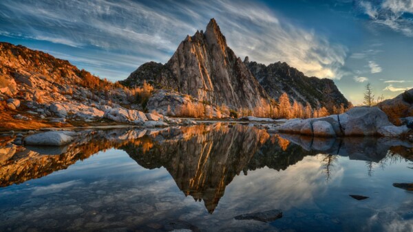 By Michael Piraino Mountain and larch trees in fall colors reflected in a pond, North Cascades of Washington