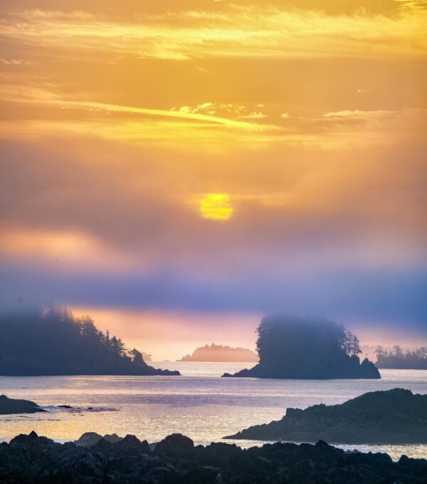 By Michael Piraino Sun rising through fog and clouds over islands in Barkley Sound, Vancouver Island Canada