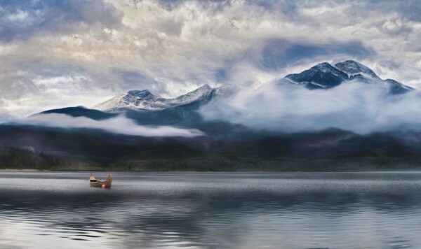 By Michael Piraino Fog, mountain and canoe at sunrise in the Canadian Rocky Mountains