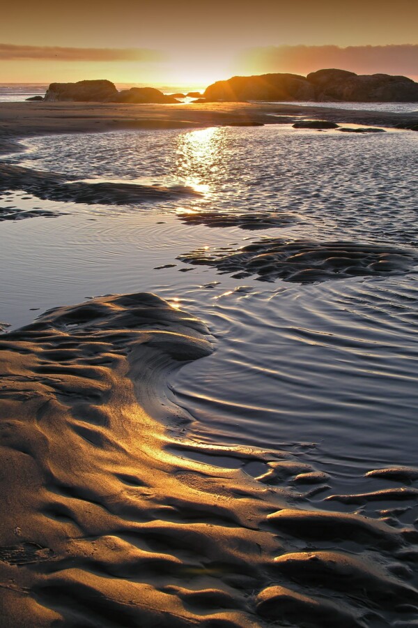 By Michael Piraino Sunset reflections and ripples on sandy beach, Olympic National Park, Washington state